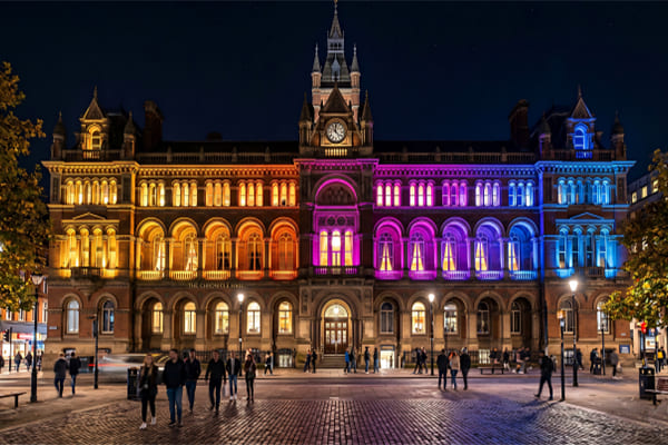 A spectrum of light from warm yellow to cool blue over a building facade